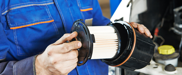 a mechanic installing a cartridge oil filter